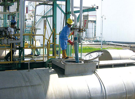 Worker standing on huge pipe inserting equipment